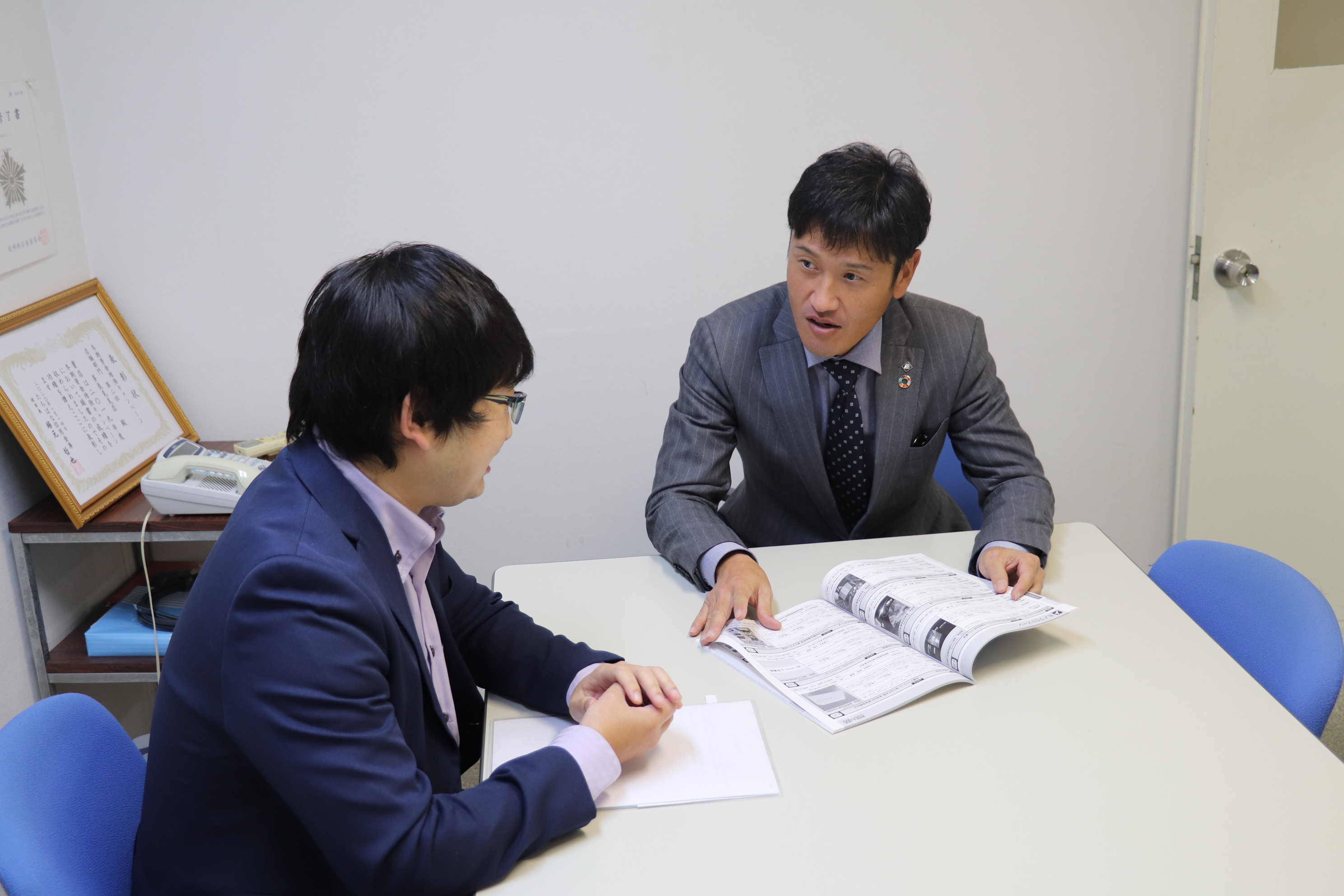 写真：後輩とディスカッションする吉田さん